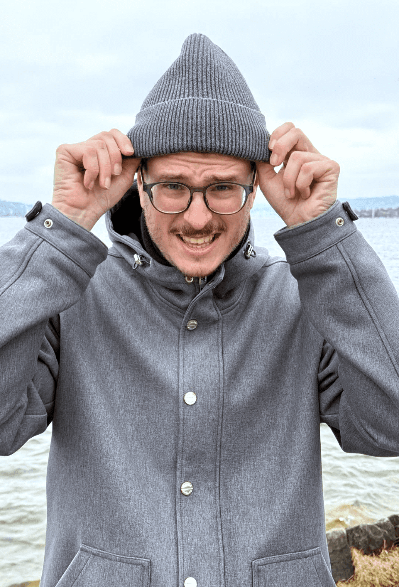 Diego wearing a grey beanie by a lake